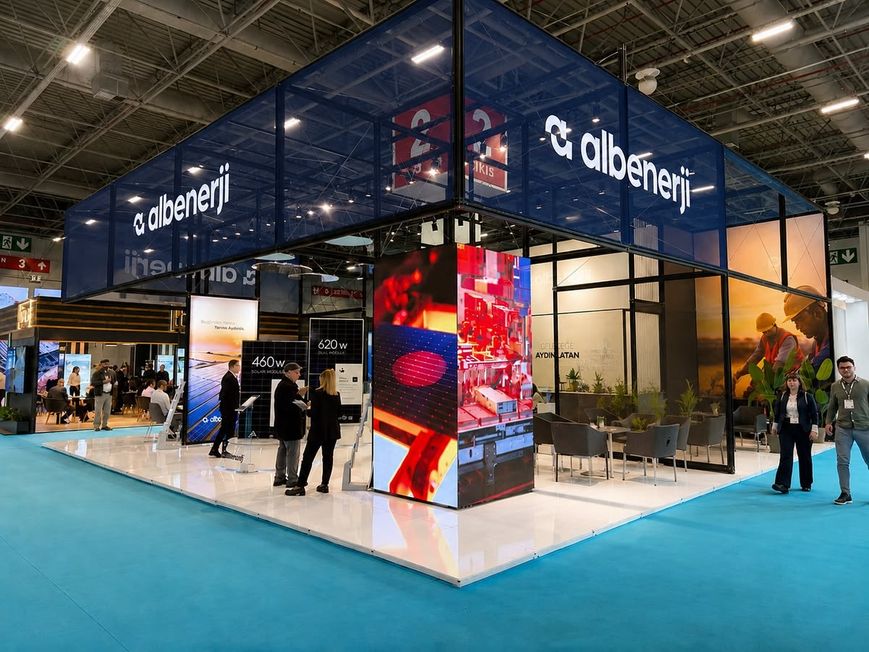 Messestand in Dunkelblau mit LED-Säule und Produktpräsentation