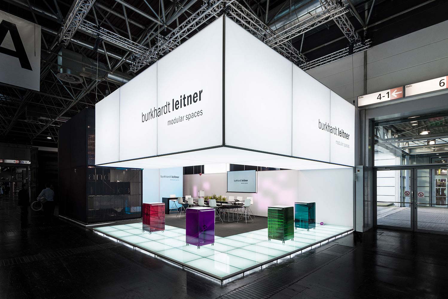 Messestand mit leuchtendem Deckenkubus und hinterleuchtetem Glasboden