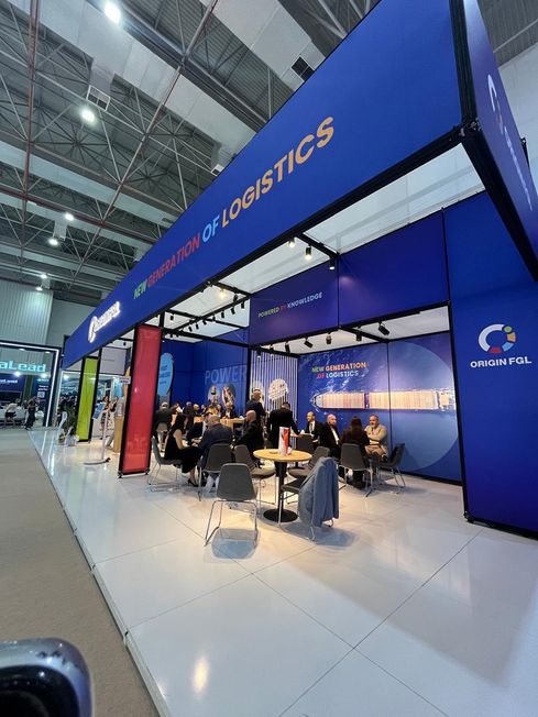 Blauer Messestand mit umlaufendem Fries und offener Loungefläche