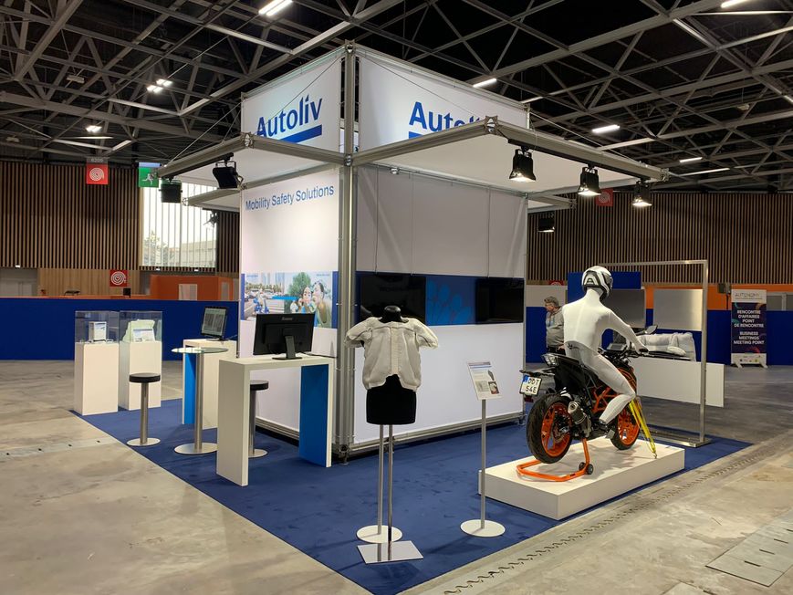 Weißer Messestand mit blauem Boden, Motorrad-Exponat und Infotheken