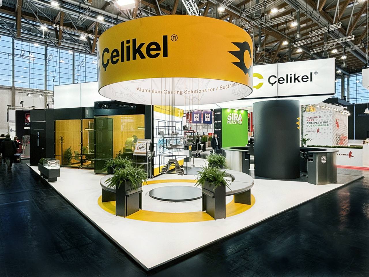 Messestand mit rundem gelbem Deckenfries und offener Ausstellungsfläche