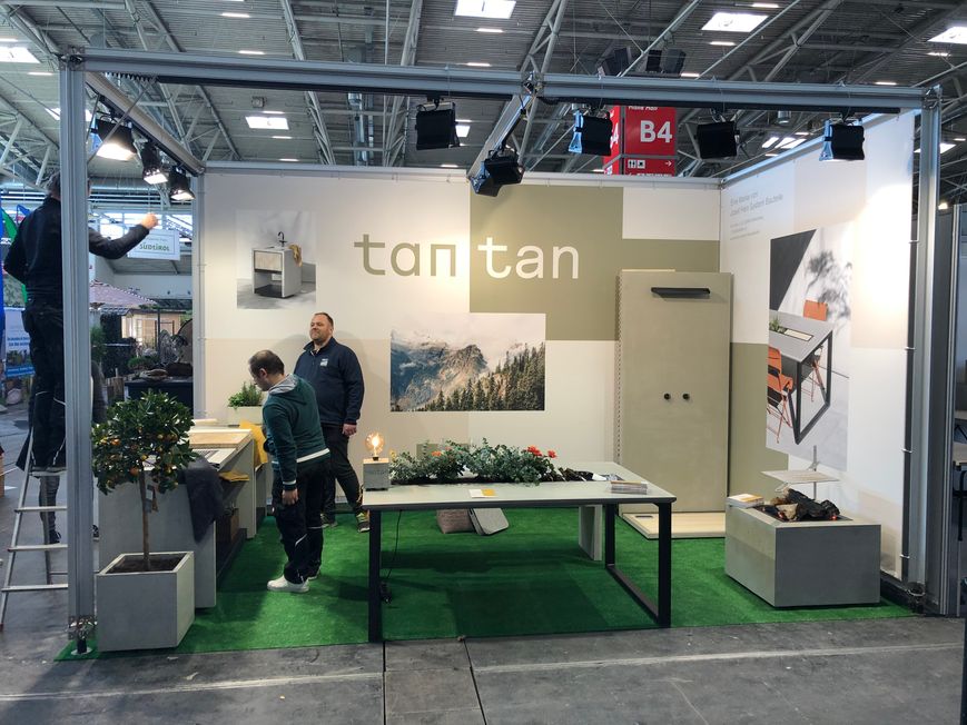 Messestand im Aufbau mit Betonmöbeln und Landschaftsgrafik